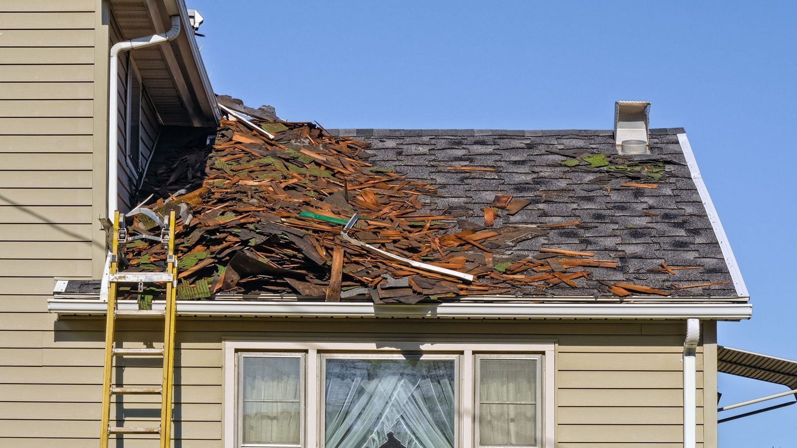 An aging asphalt shingle roof being torn off during a roof replacement on an Indianapolis-area home